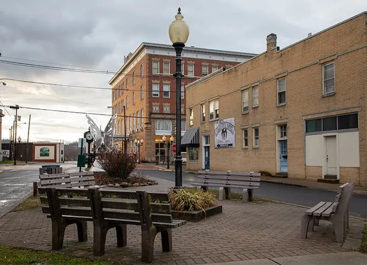 Gunn Park plaza downtown with benches, the Mothman statue, and the Lowe Hotel in the distance